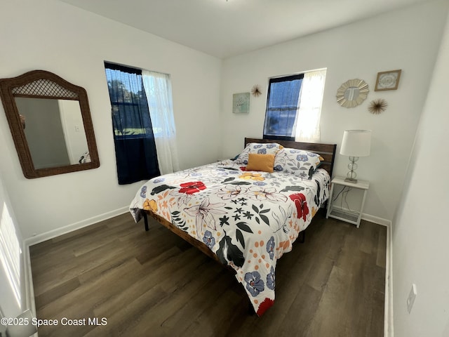 bedroom featuring multiple windows and dark wood-type flooring