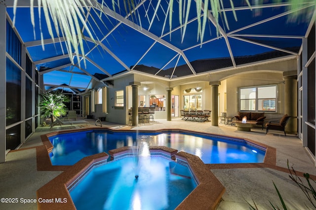 view of pool with outdoor dry bar, a patio area, a lanai, and a pool with connected hot tub