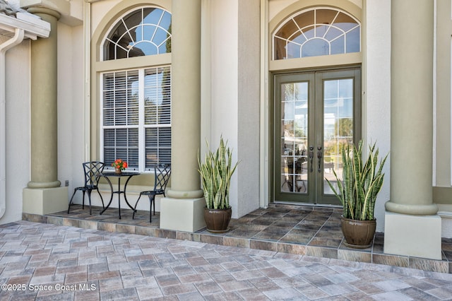 view of exterior entry with stucco siding and french doors