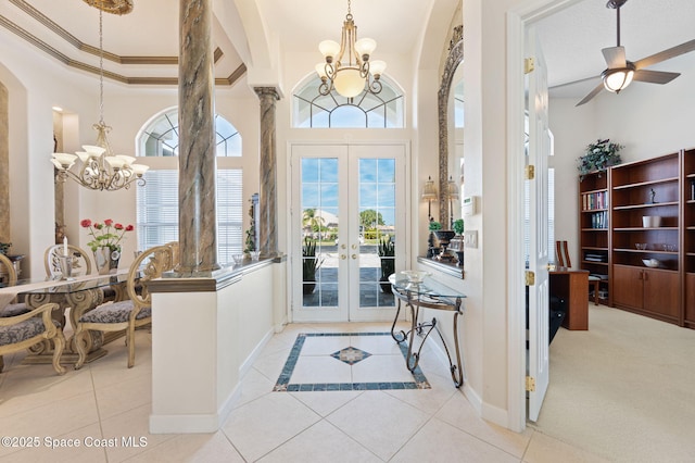 tiled foyer with arched walkways, a high ceiling, baseboards, french doors, and ornamental molding