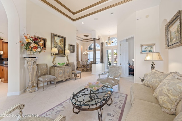 living area with ornamental molding, arched walkways, a notable chandelier, and light tile patterned floors