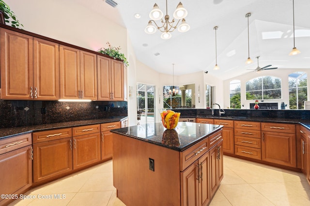 kitchen with light tile patterned floors, vaulted ceiling, a sink, and a center island