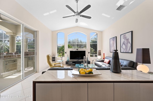 living area featuring a ceiling fan, lofted ceiling, visible vents, and light tile patterned floors