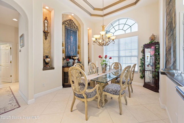 dining space featuring light tile patterned floors, ornamental molding, a raised ceiling, and a chandelier