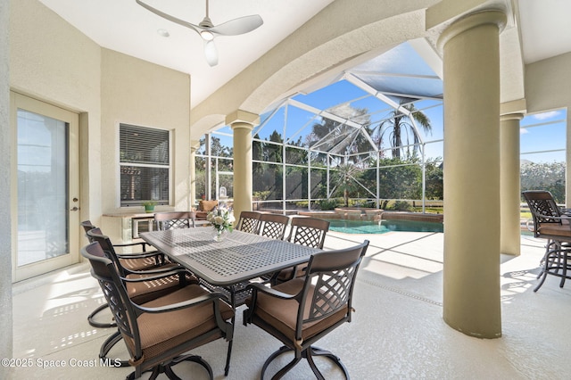 view of patio / terrace featuring glass enclosure, ceiling fan, a pool with connected hot tub, and outdoor dining space