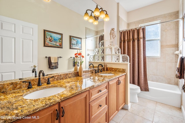 full bath featuring toilet, double vanity, a sink, and tile patterned floors