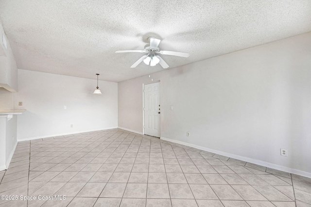 unfurnished room with ceiling fan and a textured ceiling