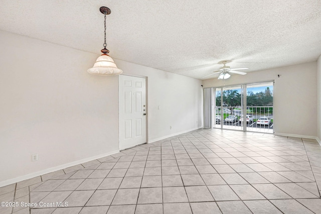 tiled empty room featuring a textured ceiling and ceiling fan