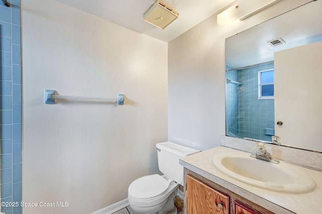 bathroom featuring vanity, toilet, and a tile shower