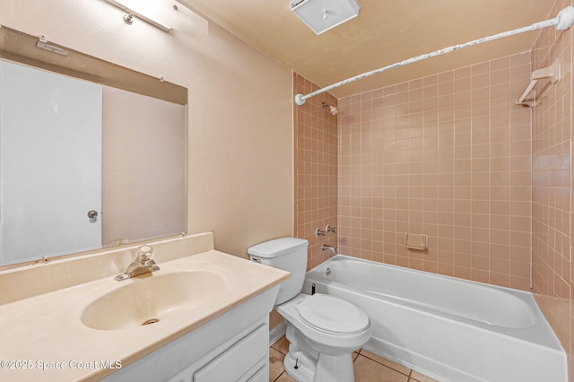 full bathroom featuring tile patterned flooring, vanity, tiled shower / bath combo, and toilet