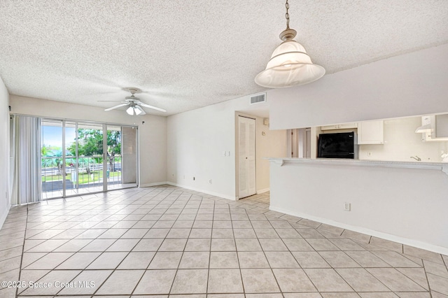 unfurnished living room featuring light tile patterned floors, a textured ceiling, and ceiling fan