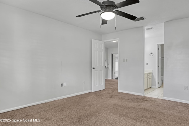 unfurnished bedroom featuring ceiling fan, ensuite bath, and light carpet