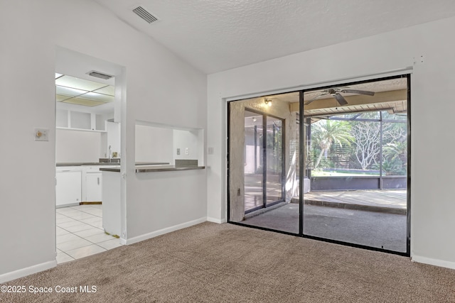 carpeted spare room featuring sink, a textured ceiling, and ceiling fan