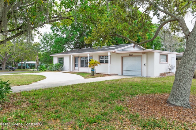 ranch-style house featuring concrete driveway, an attached garage, a front yard, and stucco siding