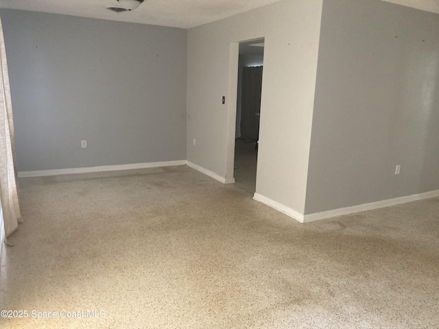 empty room with speckled floor and baseboards