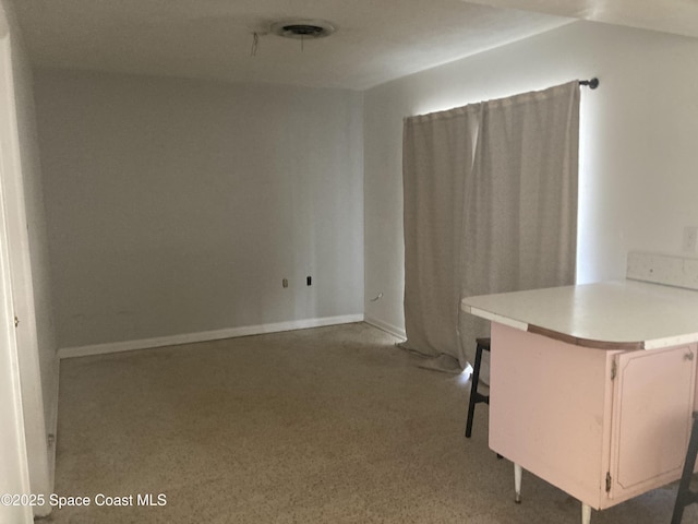 unfurnished room with baseboards