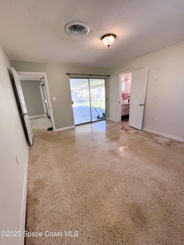 unfurnished room with speckled floor, baseboards, and visible vents