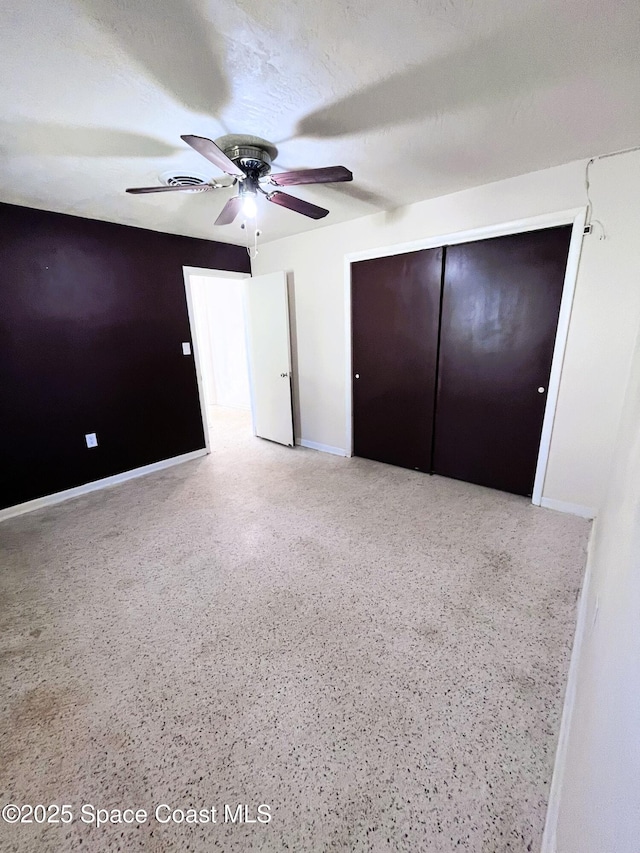 unfurnished bedroom with a closet, baseboards, and speckled floor