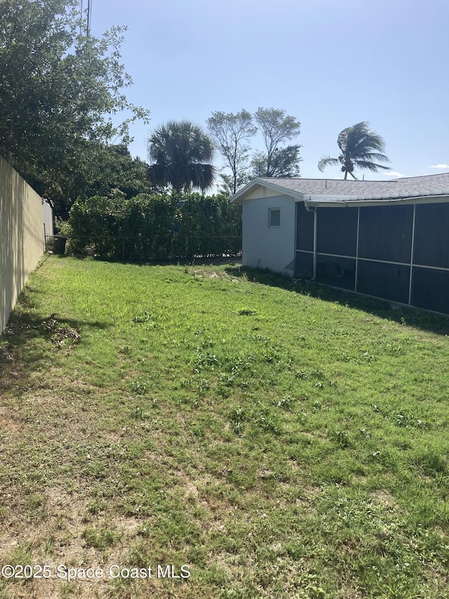 view of yard with a sunroom and fence