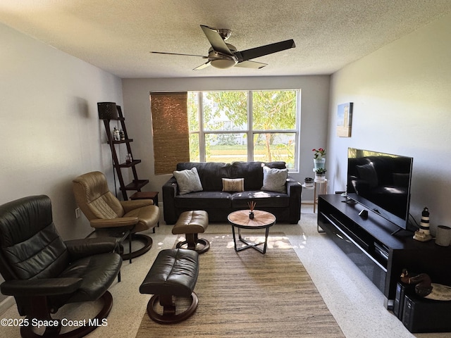 carpeted living room with ceiling fan and a textured ceiling