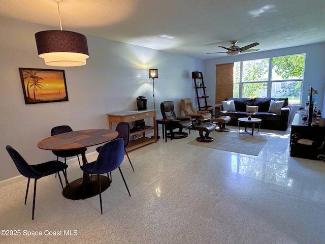 dining area featuring ceiling fan and a textured ceiling