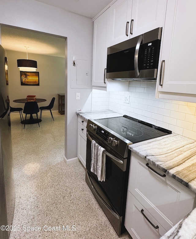 kitchen with electric stove, tasteful backsplash, light stone countertops, and white cabinets