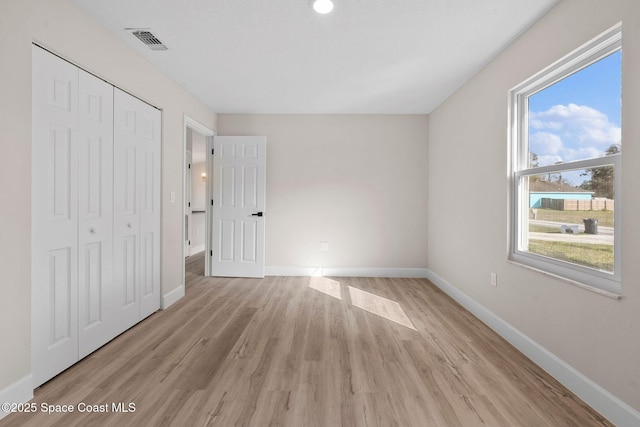 unfurnished bedroom featuring a closet and light hardwood / wood-style flooring