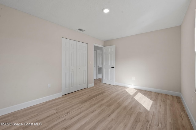 unfurnished bedroom featuring a closet and light wood-type flooring