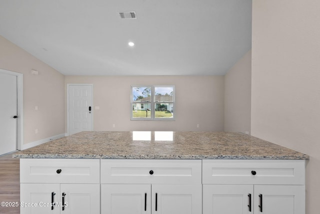 kitchen featuring white cabinetry and light stone counters