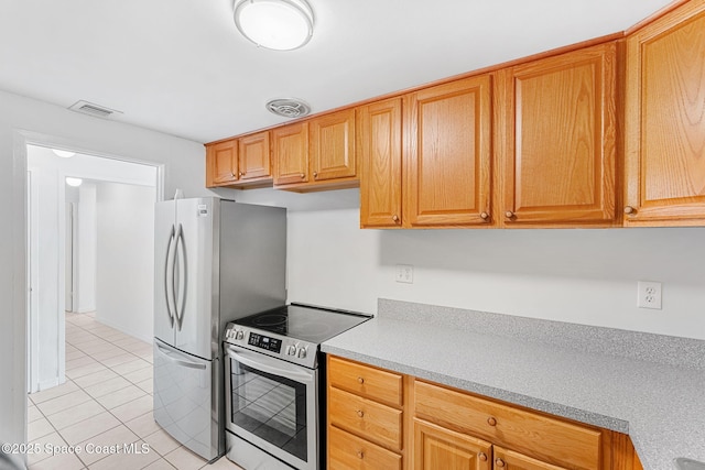 kitchen with appliances with stainless steel finishes, light countertops, visible vents, and light tile patterned flooring