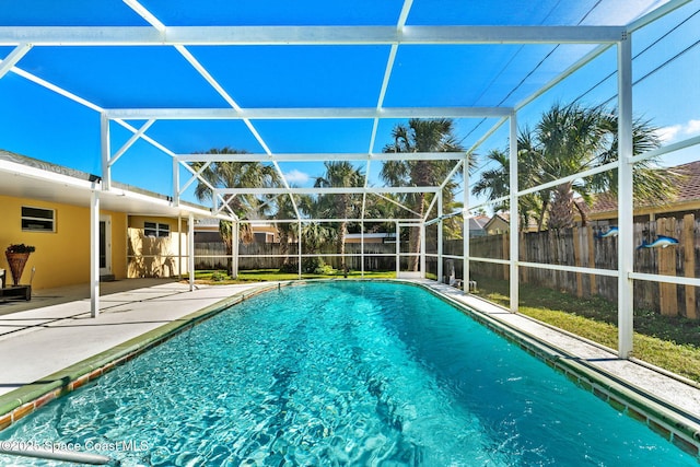 view of swimming pool featuring a patio and glass enclosure