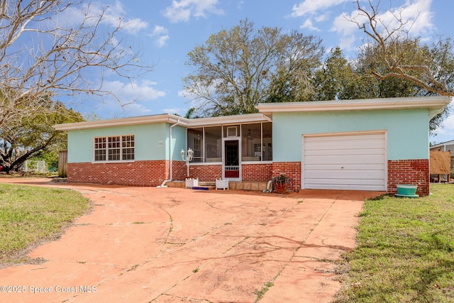 ranch-style home featuring driveway, a sunroom, an attached garage, and brick siding