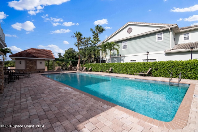 view of pool featuring an outbuilding and a patio area