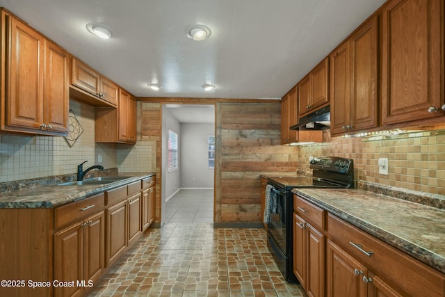 kitchen featuring dark stone counters, sink, black range with electric cooktop, and decorative backsplash