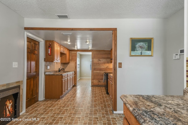 kitchen with sink, a textured ceiling, and decorative backsplash