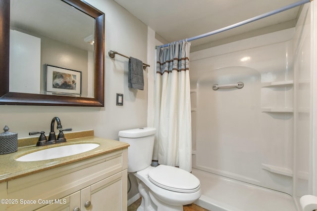 bathroom featuring vanity, walk in shower, and toilet