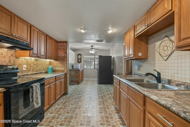 kitchen featuring black appliances, sink, backsplash, light stone counters, and ceiling fan