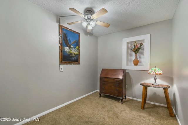 living area with ceiling fan, light colored carpet, and a textured ceiling