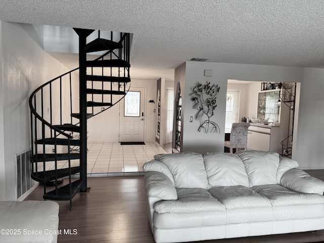 living room with plenty of natural light, hardwood / wood-style floors, and a textured ceiling