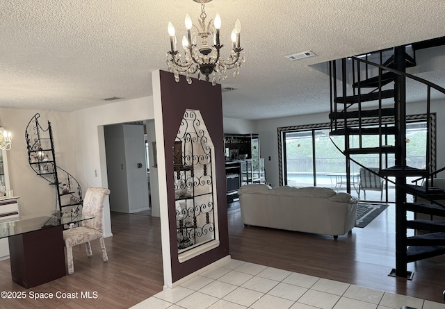 interior space featuring tile patterned floors, a textured ceiling, and a notable chandelier