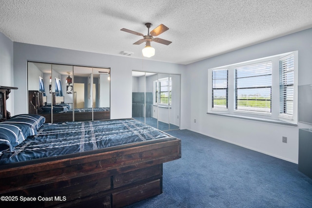 carpeted bedroom featuring a textured ceiling and ceiling fan