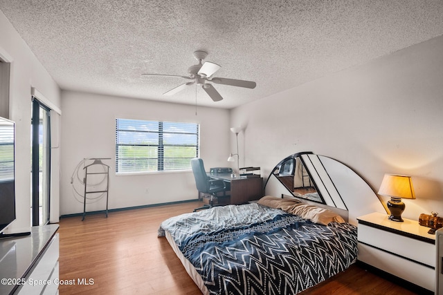 bedroom featuring ceiling fan, hardwood / wood-style floors, and a textured ceiling