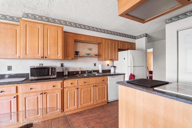 kitchen featuring white appliances, tile patterned flooring, sink, and a textured ceiling