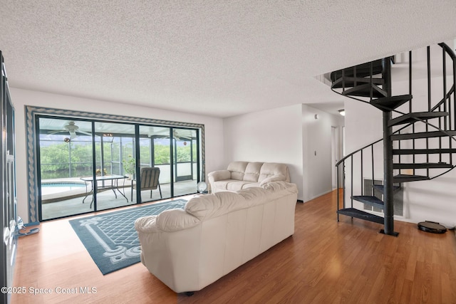 living room with wood-type flooring and a textured ceiling