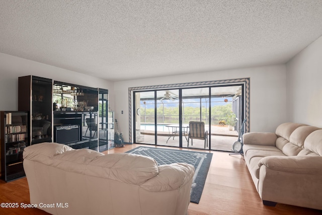 living room with light hardwood / wood-style floors and a textured ceiling