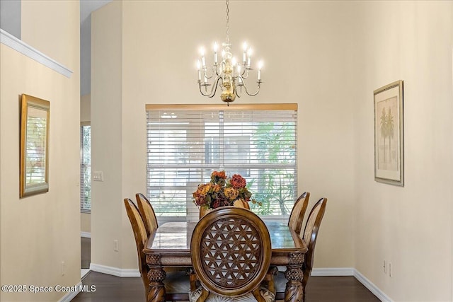 dining room featuring baseboards, plenty of natural light, dark wood-type flooring, and a chandelier