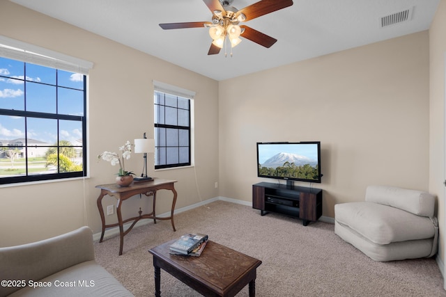 living room featuring ceiling fan, plenty of natural light, visible vents, and baseboards