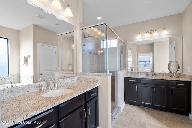 full bathroom with a stall shower, two vanities, a sink, and tile patterned flooring