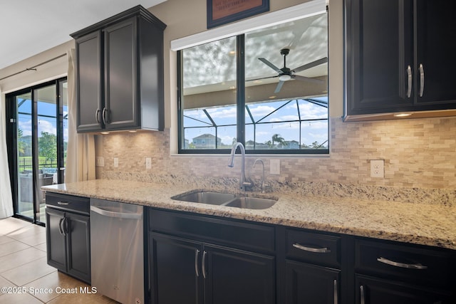 kitchen featuring dishwasher, light tile patterned flooring, a sink, and dark cabinets