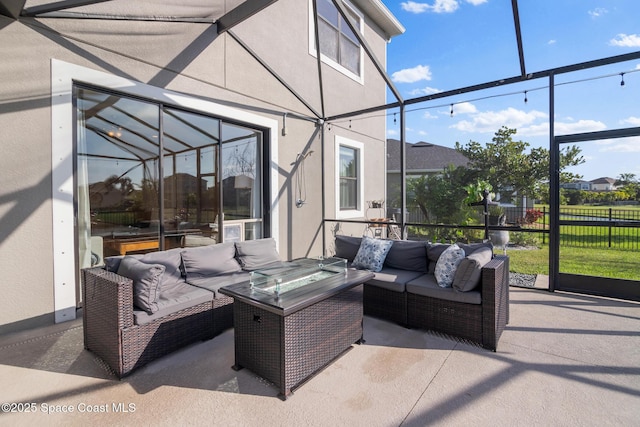 view of patio / terrace featuring an outdoor hangout area, glass enclosure, and fence